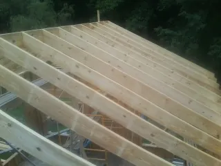 New roof rafters set over an addition before sheathing in Whigham