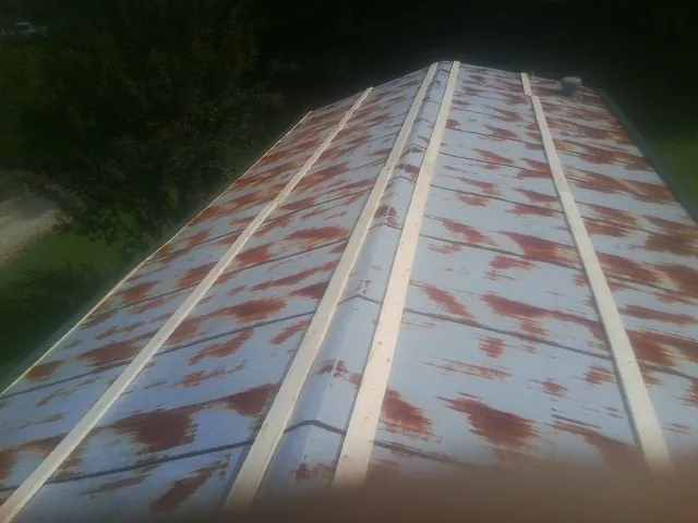 Rusted metal roof panels with new wood purlins before replacement — Storm Damage Roof Repair in Whigham by Roofing Brothers