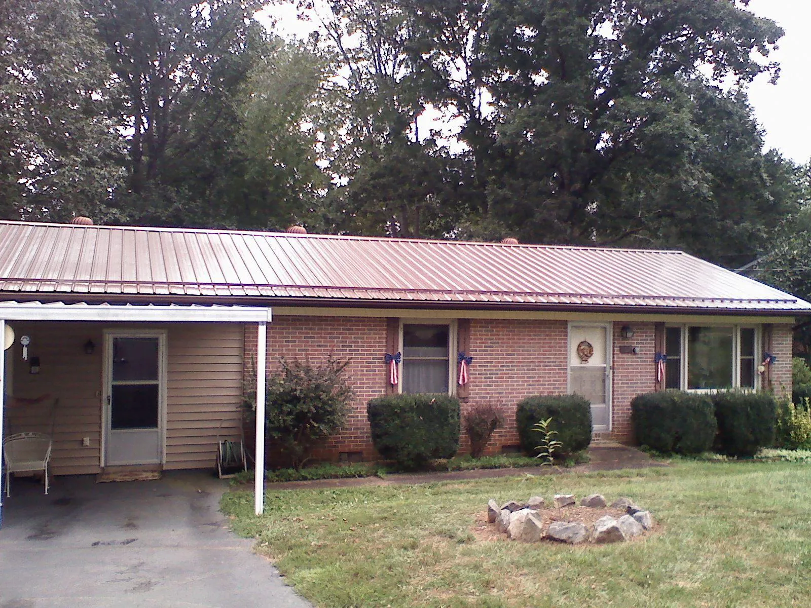 Bronze metal roof and carport on a brick ranch home — Roof Repair work by our crew in Whigham
