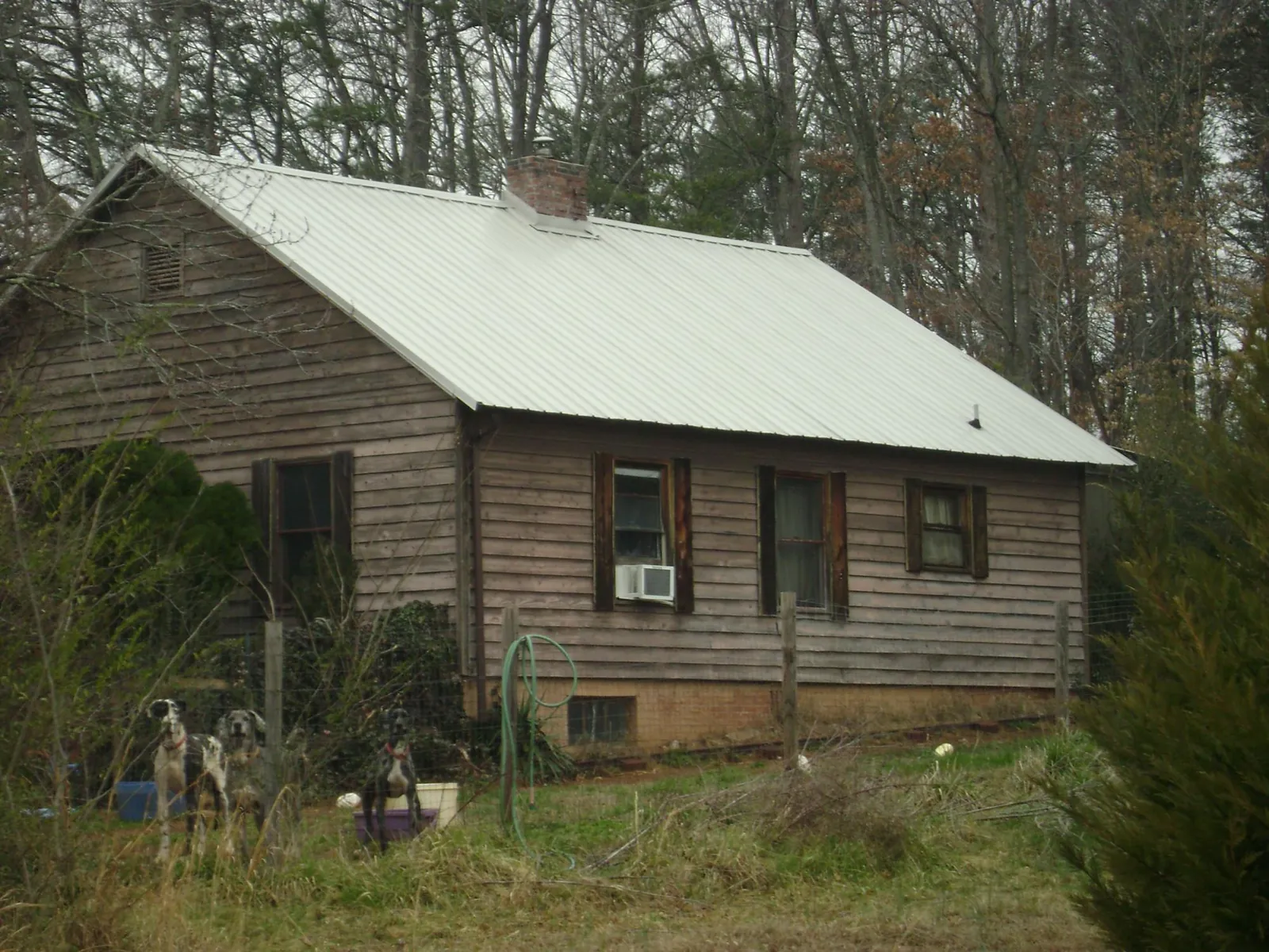 White metal roof on an old wood sided farmhouse, from a Metal Roof Installation job in Whigham